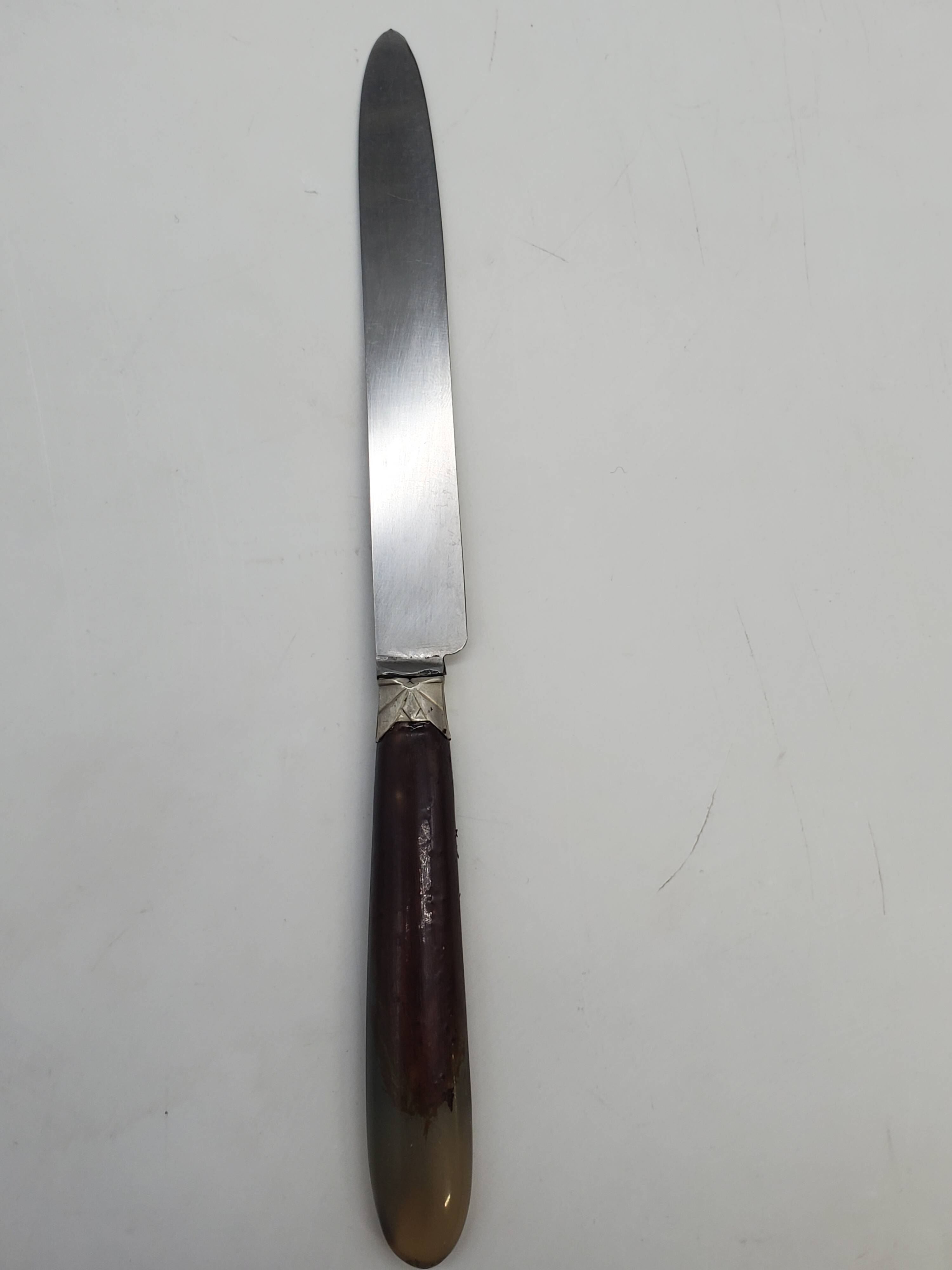 Set of 12 dessert knives with two-tone horn-effect resin handles.