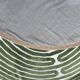 Circular rug with green decor on a cream background from the Labyrinth.