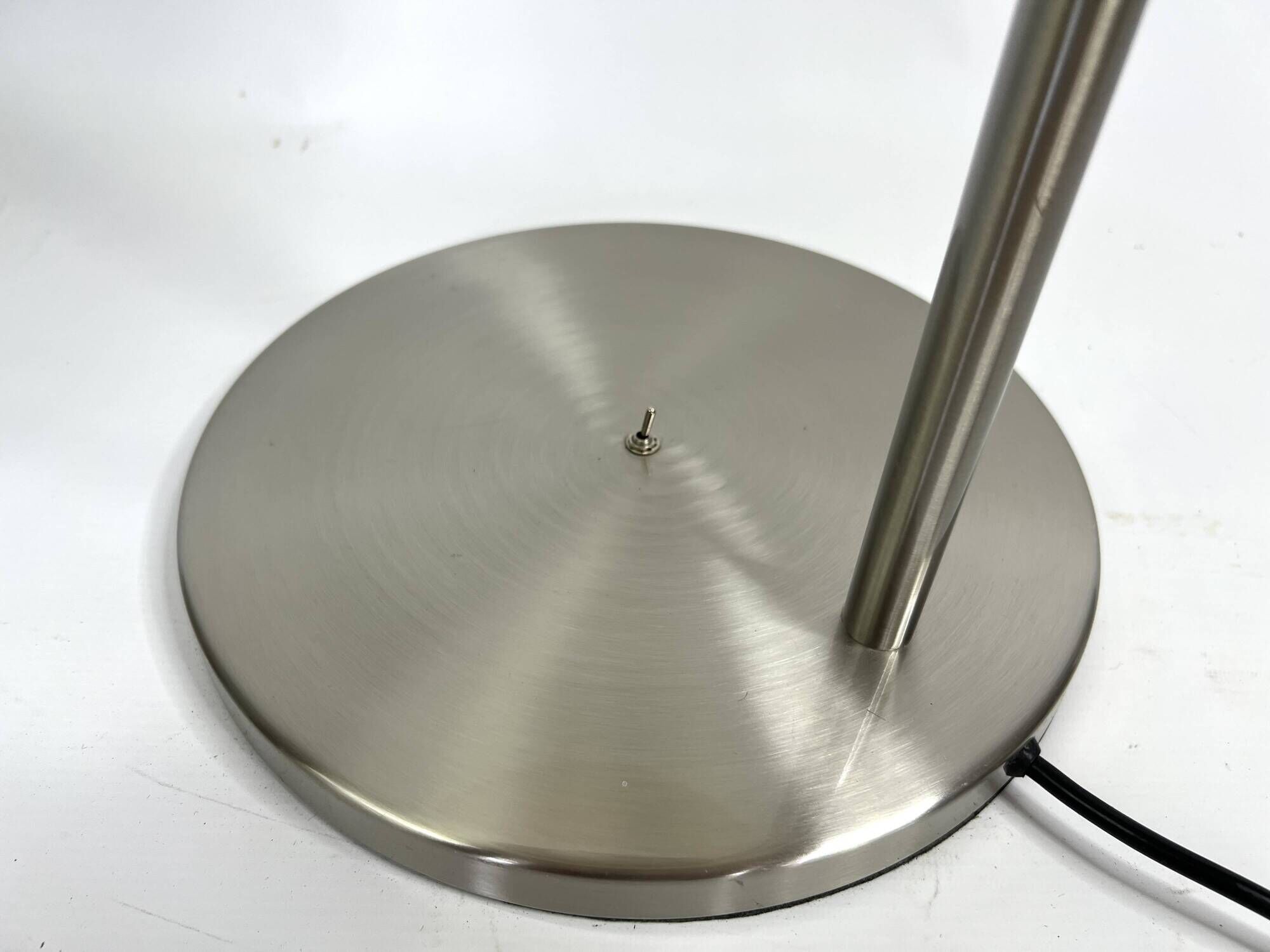 Large brushed metal table lamp with an ecru shade.