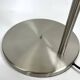 Large brushed metal table lamp with an ecru shade.