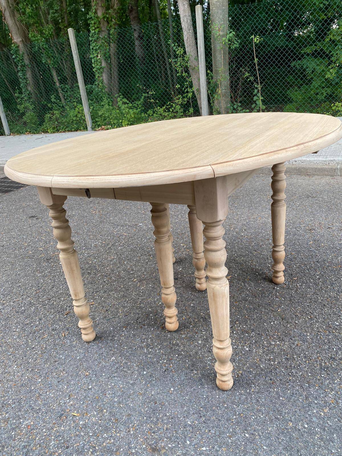 Round dining table with extendable leaves, Louis Philippe style, stripped in raw oak.