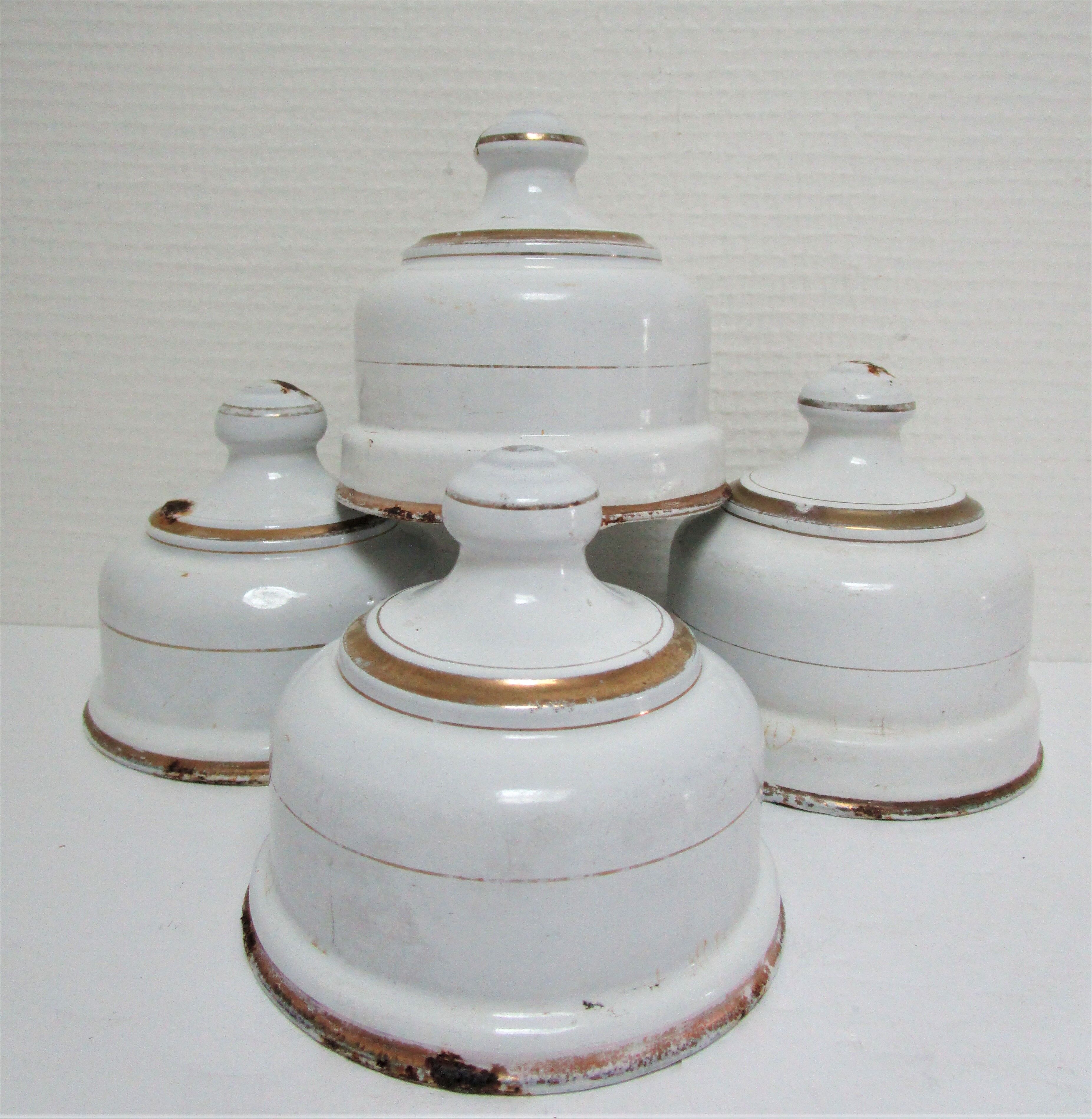 Four white enamelled metal cheese bells early twentieth century