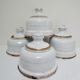 Four white enamelled metal cheese bells early twentieth century