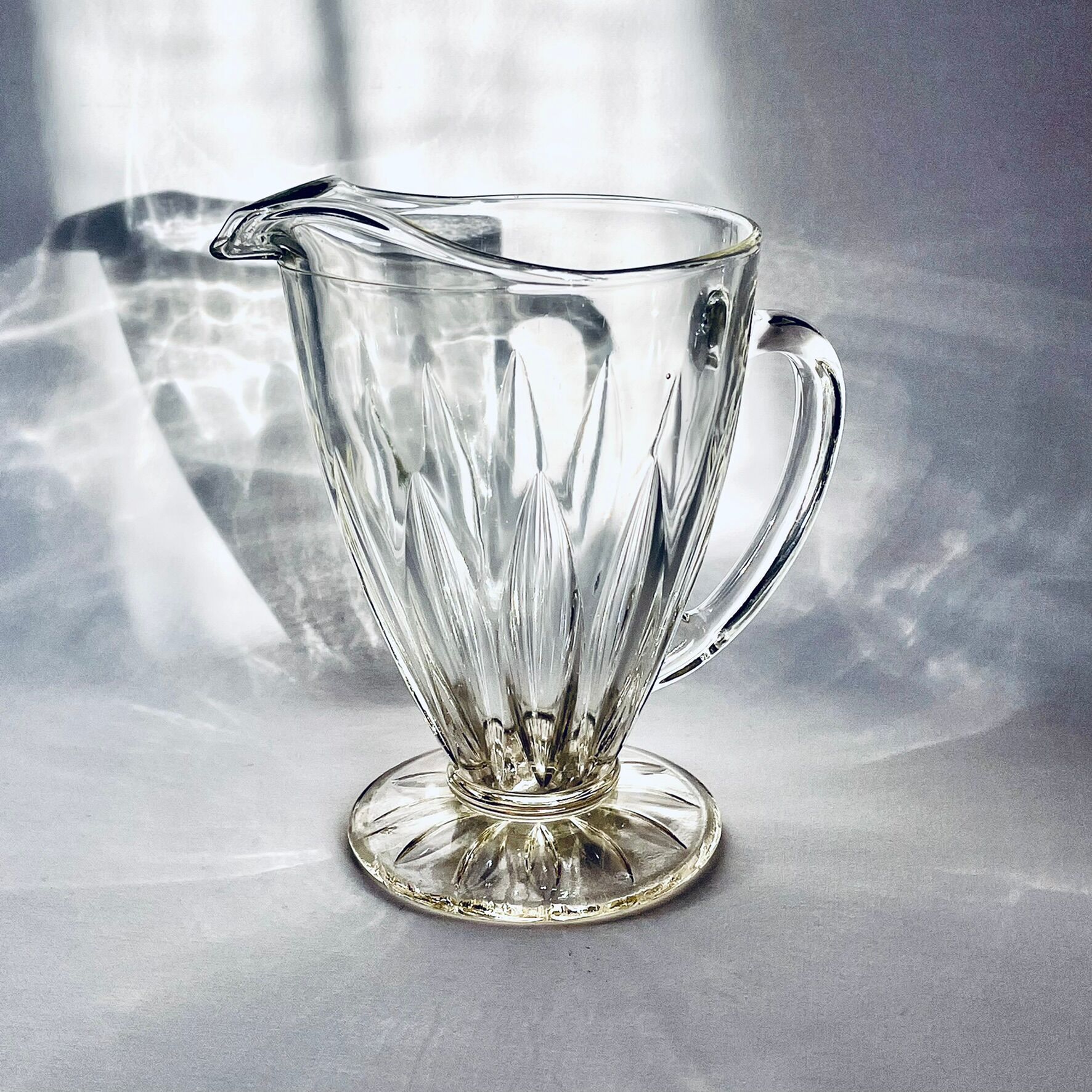 Glass pitcher on base