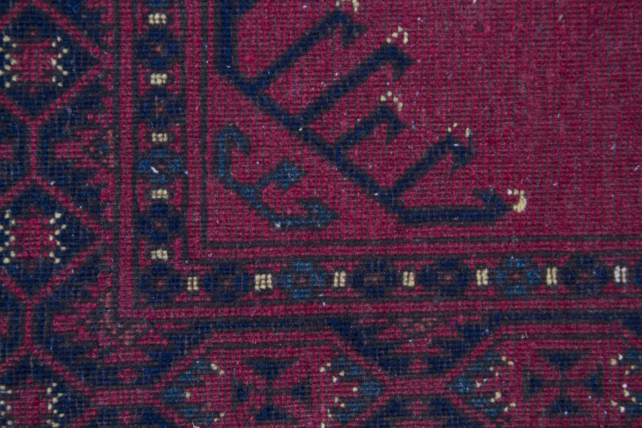 Tapis de couloir en laine à motifs géométriques bordeaux, noué à la main, style tribal afghan.
