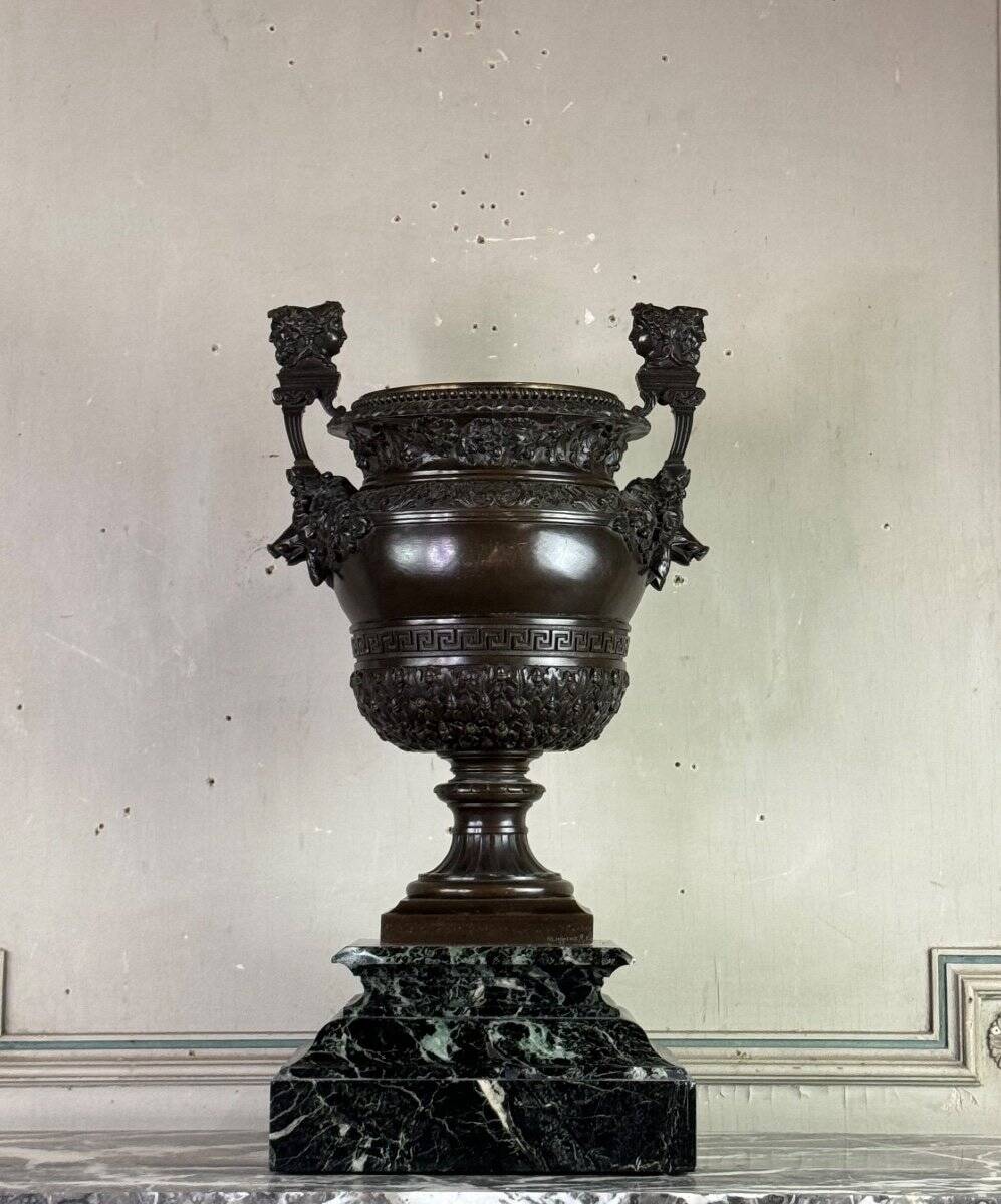 Patinated bronze vase with handles topped by bicéphalic busts, 19th century.