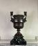 Patinated bronze vase with handles topped by bicéphalic busts, 19th century.
