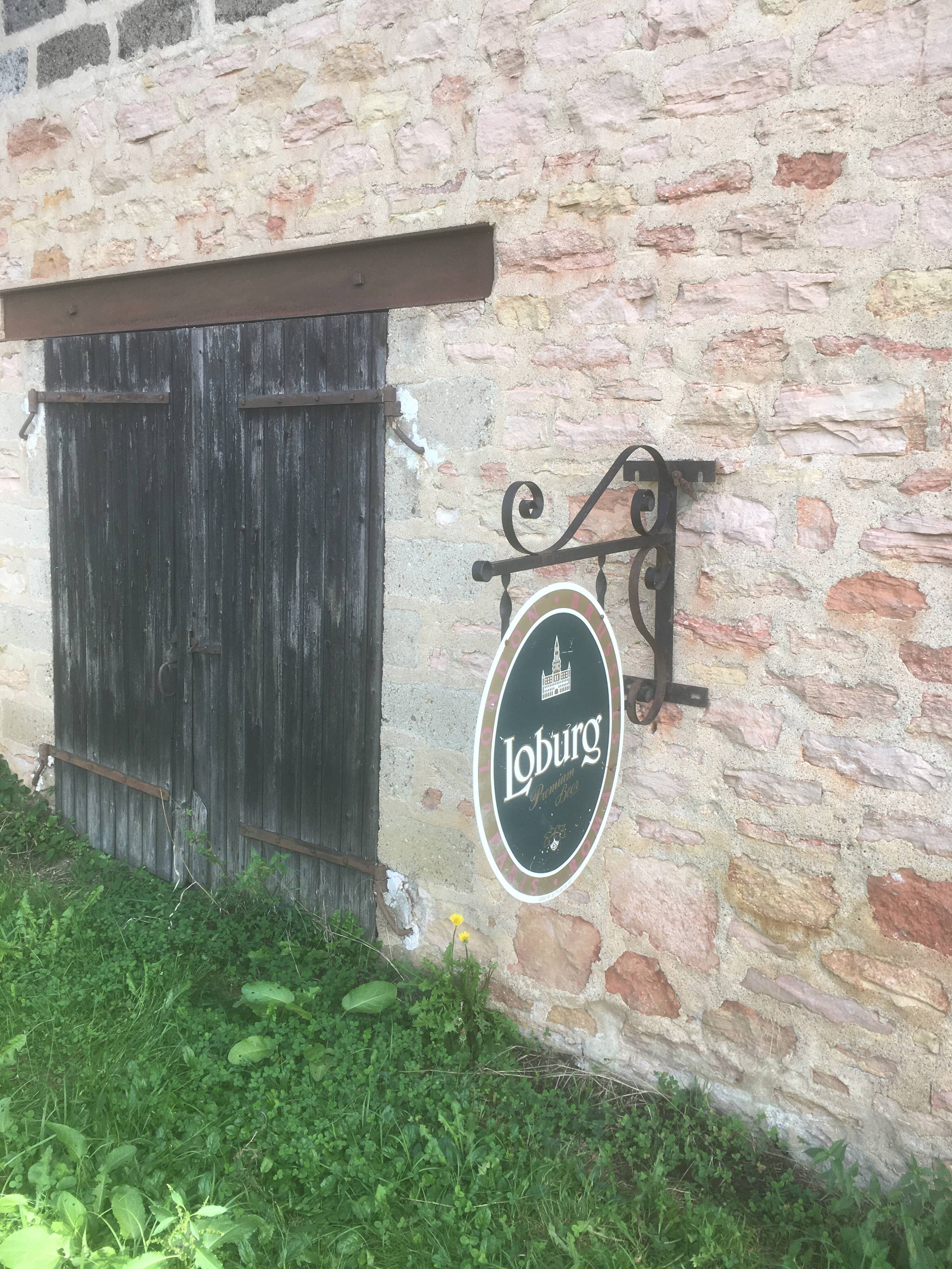Double-sided "Loburg Beer" metal sign on wrought iron bracket