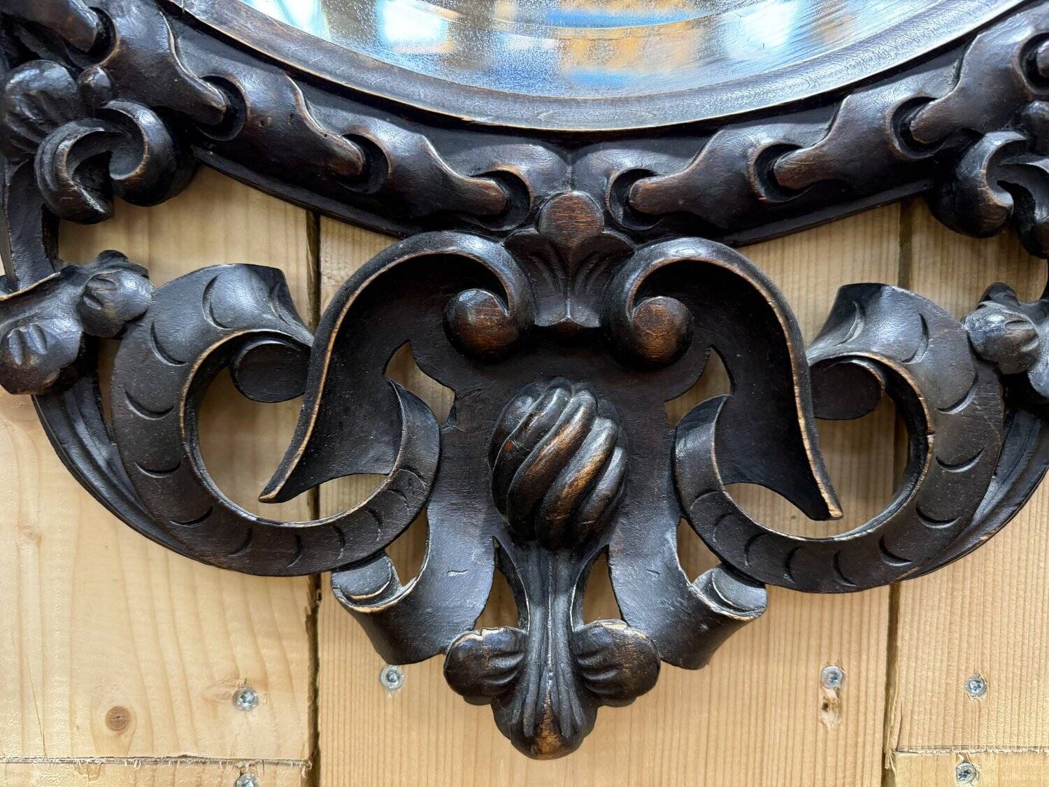Oval mirror in carved wood with dragon heads.