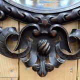 Oval mirror in carved wood with dragon heads.