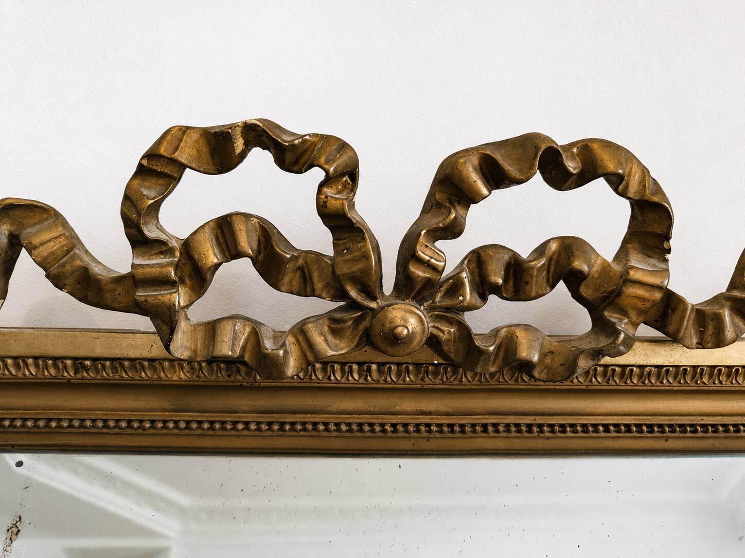 Large Napoleon III mirror 130 × 93 cm — gilded frame sculpted with ribbon pediment.