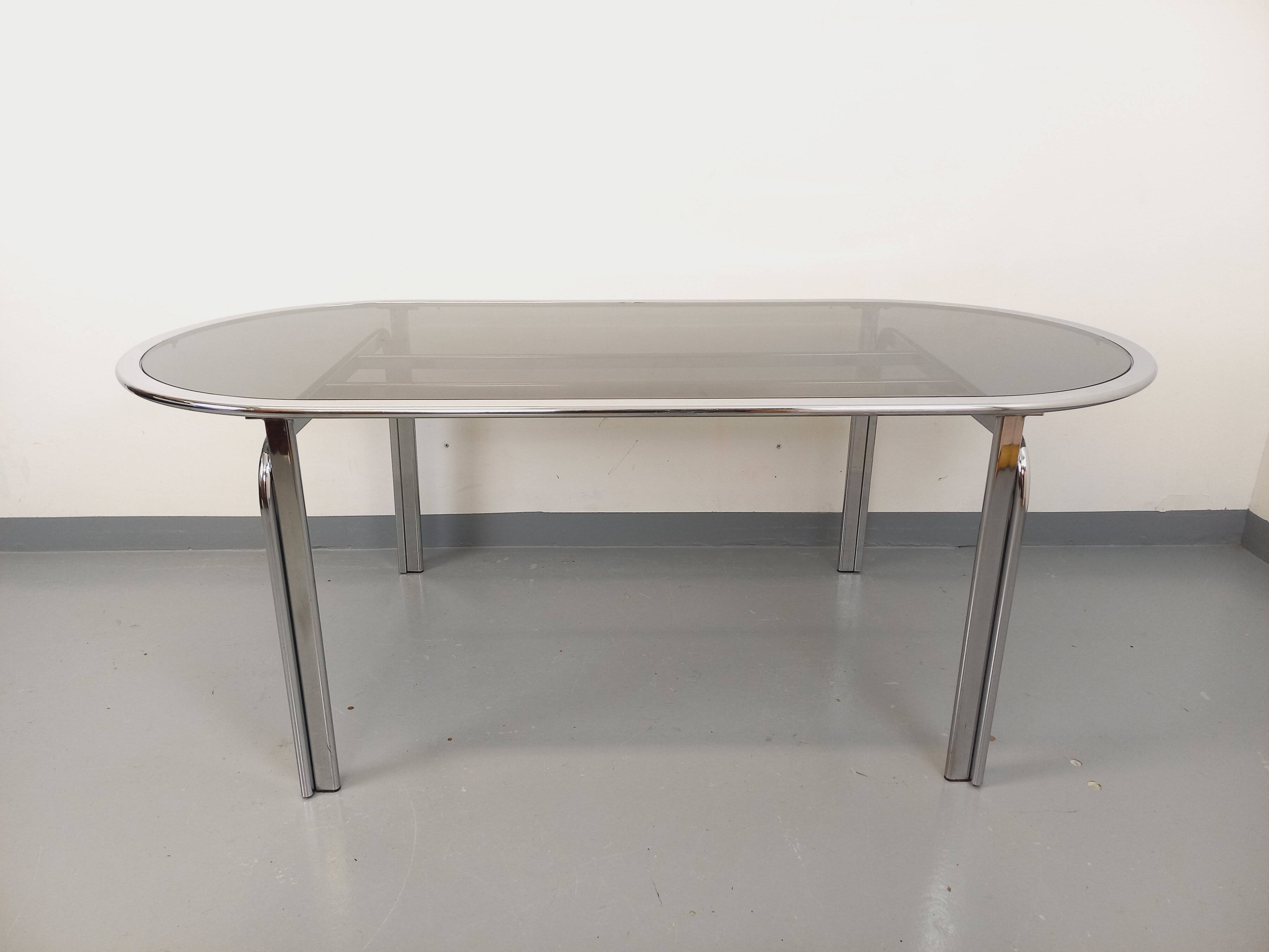 Vintage oval dining table in smoked glass and chrome metal, Space Age style.