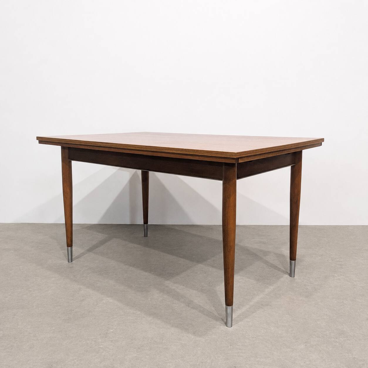Vintage extendable dining table with tapered legs.