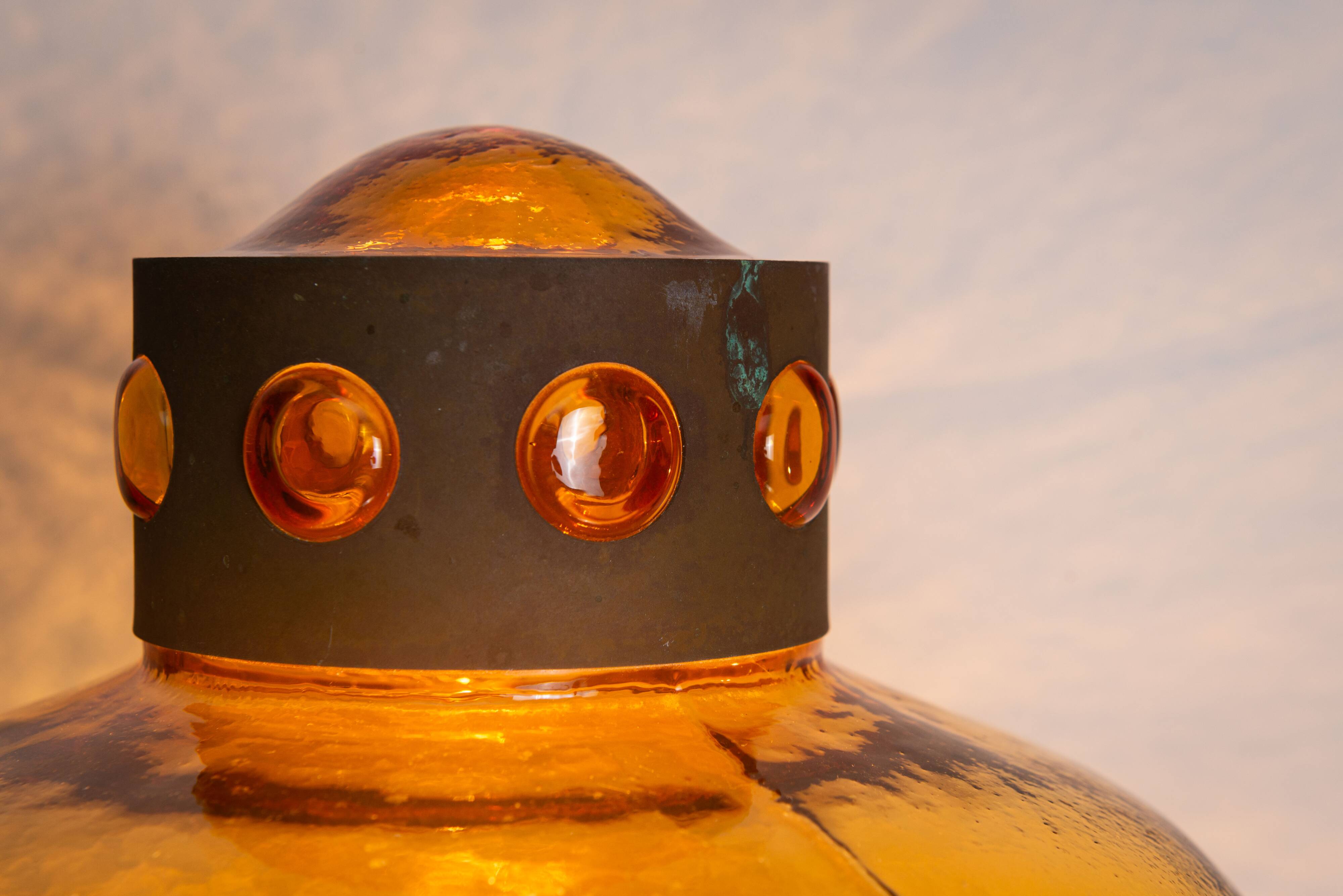 Pair of brass wall lamps with decorated amber coloured shades