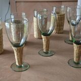Four stemmed glasses surrounded by rattan.
