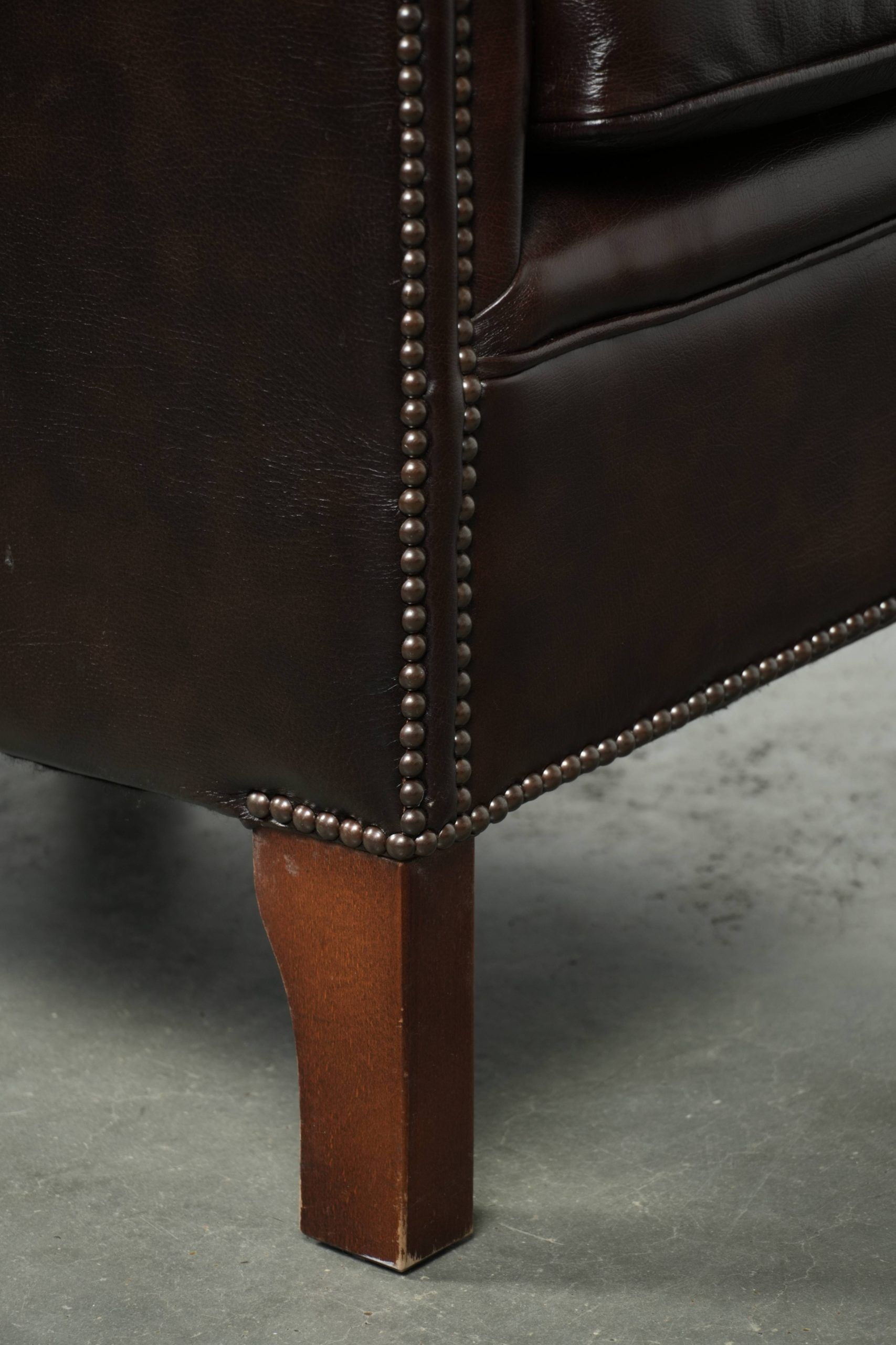 Dark cow leather club armchair with a stylish design in English style