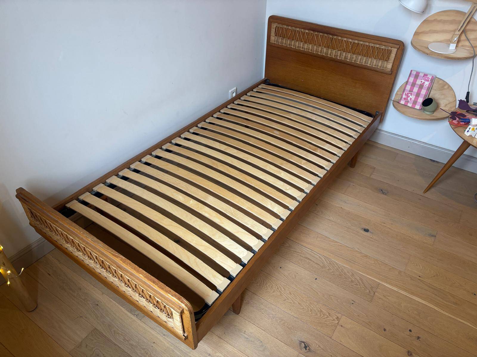 Vintage single bed made of rattan from the 1970s with a mattress.