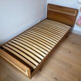 Vintage single bed made of rattan from the 1970s with a mattress.