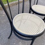Pair of black steel and plastic cane bistro chairs