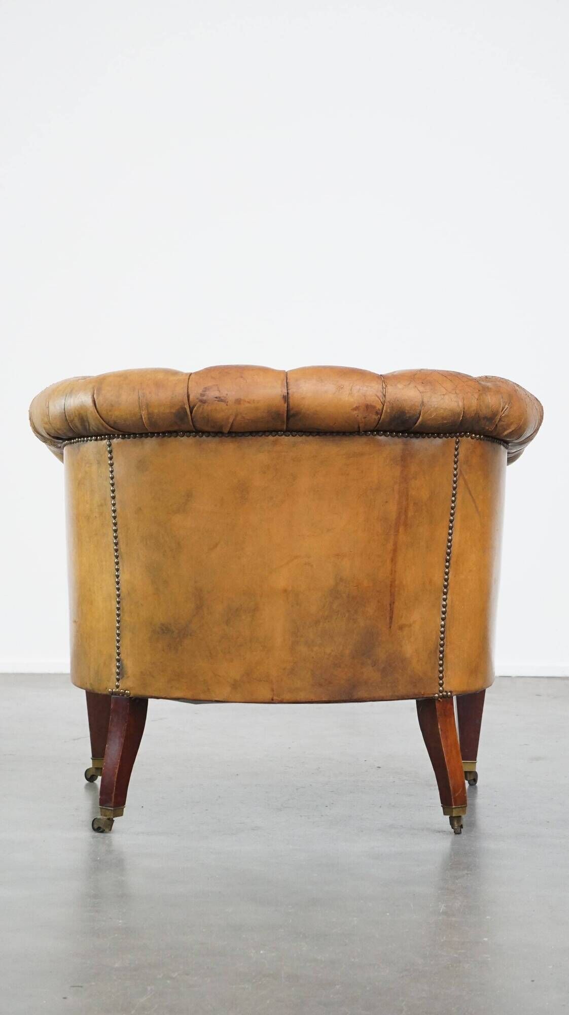 Antique, characteristic sheepskin chesterfield club chair on wheels