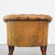 Antique, characteristic sheepskin chesterfield club chair on wheels