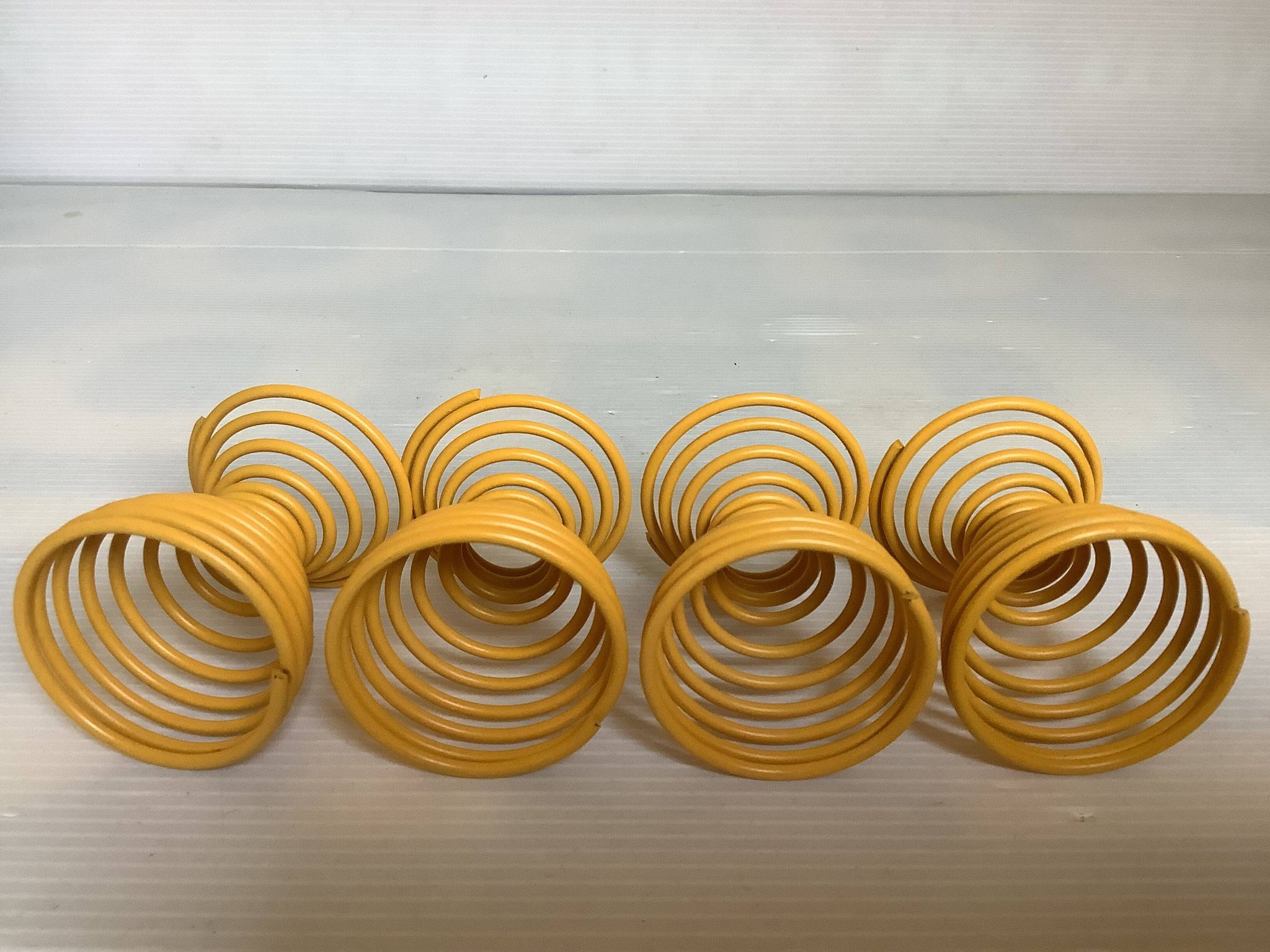 Four yellow spiral spring egg cups