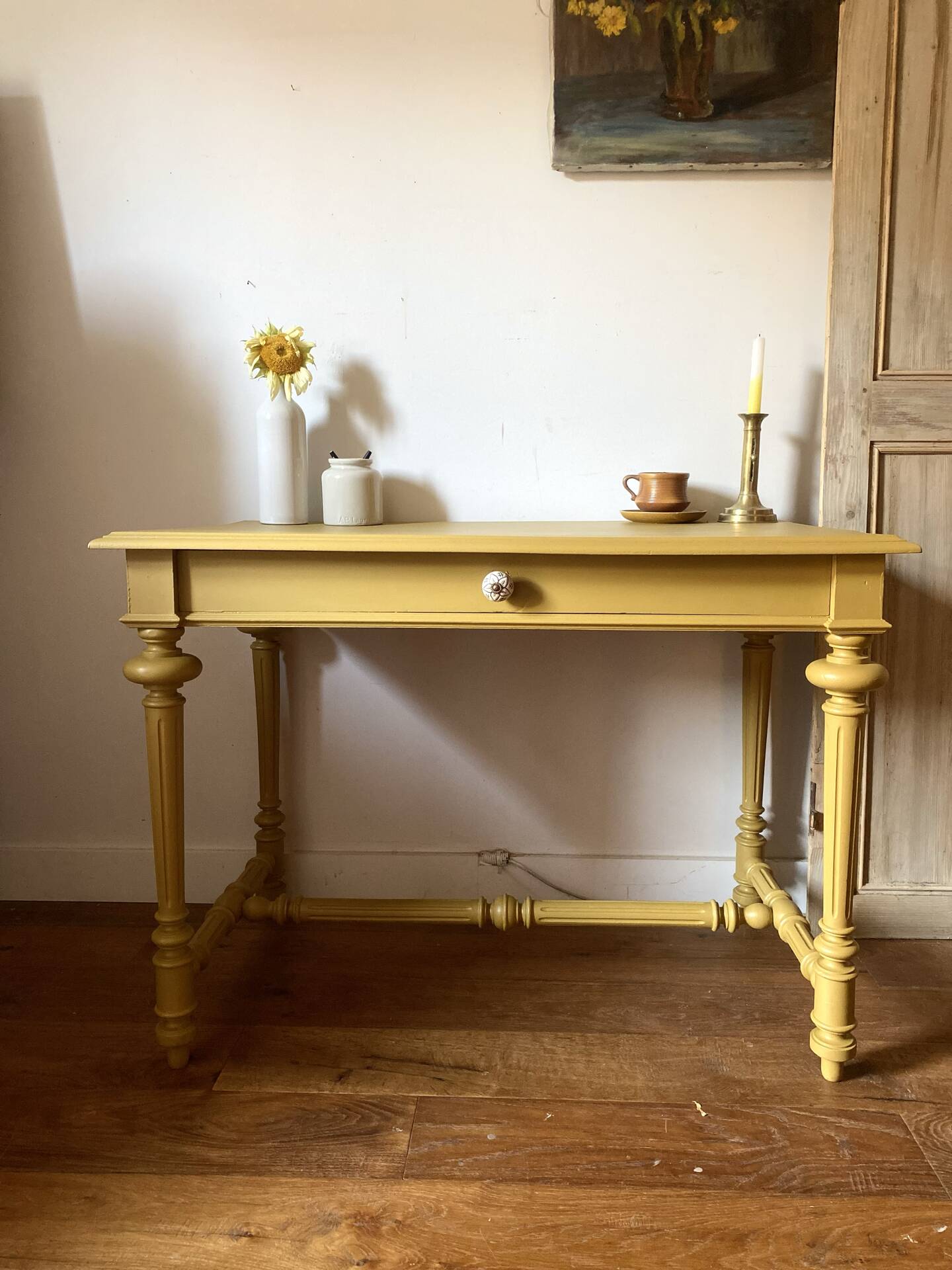 Desk table from the late 19th century, painted mustard, with turned stretcher.