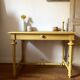 Desk table from the late 19th century, painted mustard, with turned stretcher.