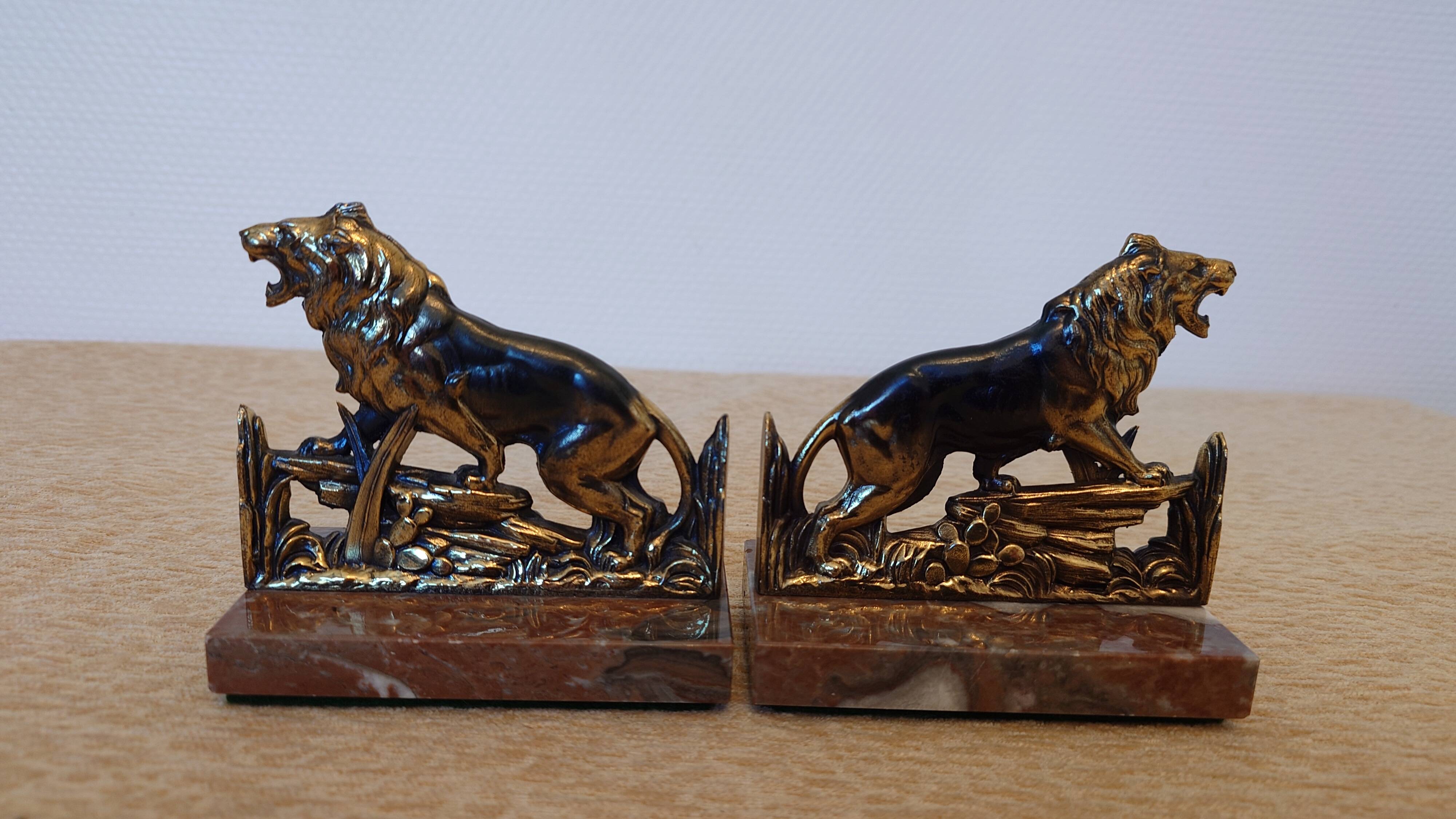 Small roaring lion bookends in patinated metal on a marble base.