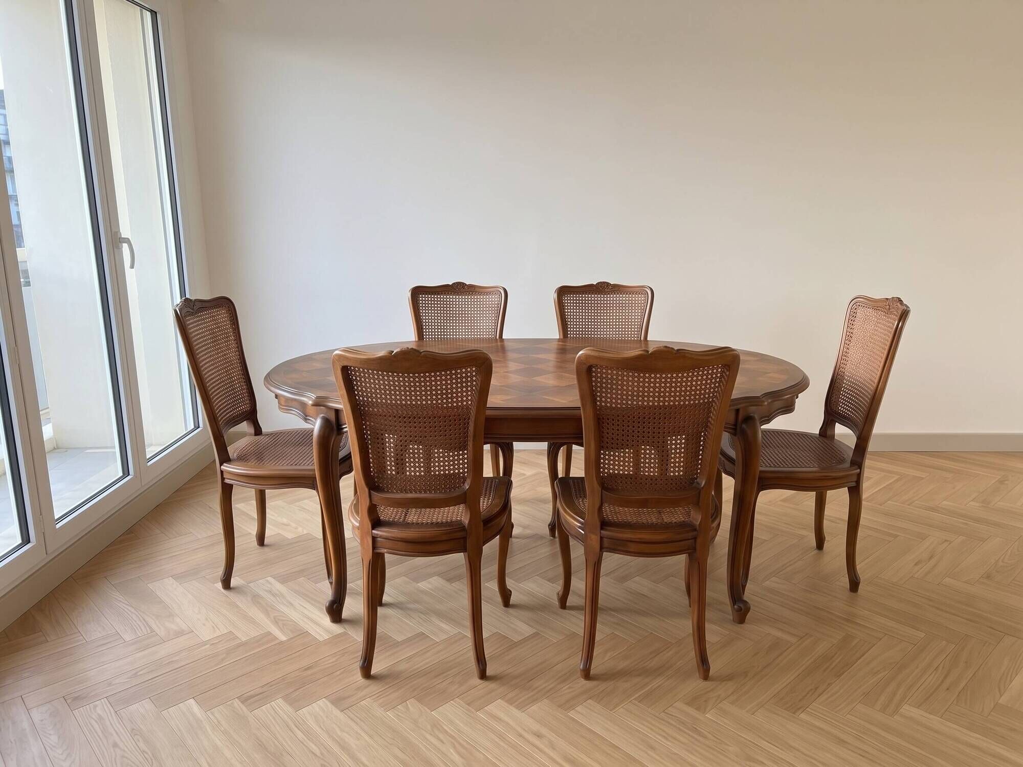 Oval dining table and 6 caned chairs in Louis XVI style made of wood.