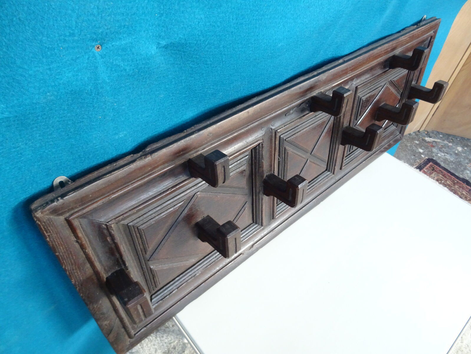 Wall-mounted coat rack in solid oak with 9 hooks.