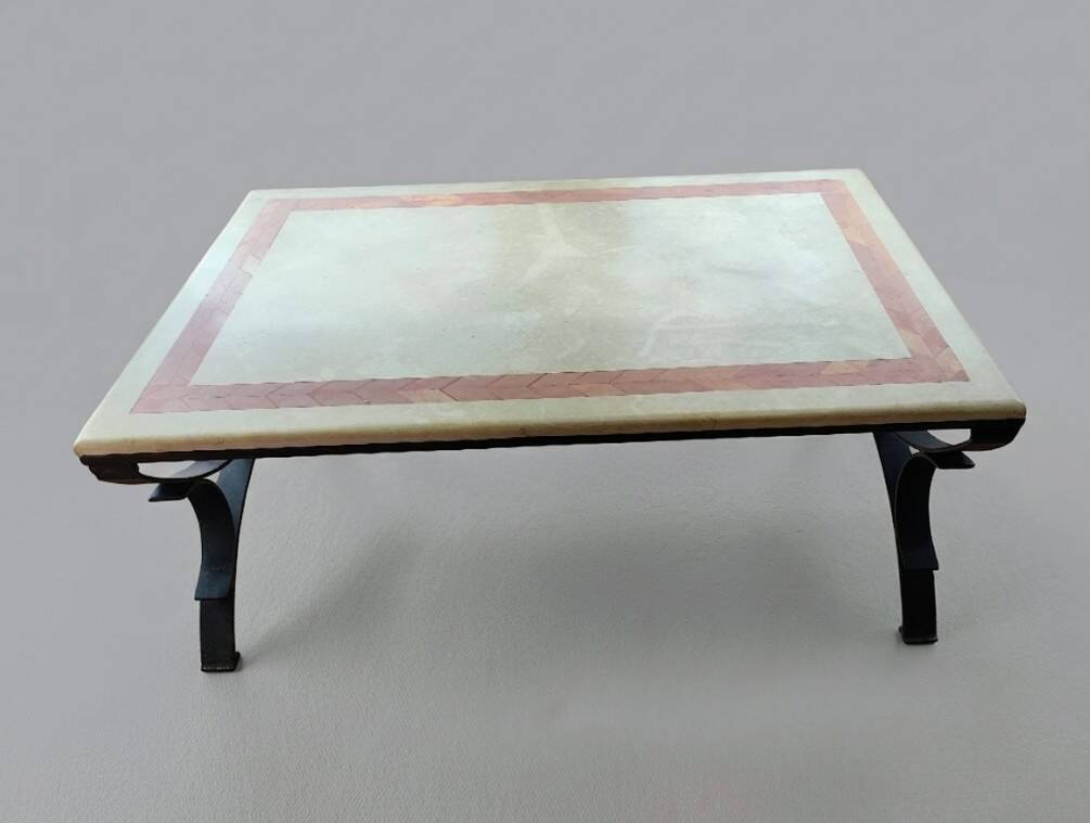 Rectangular coffee table with a stone top on wrought iron.