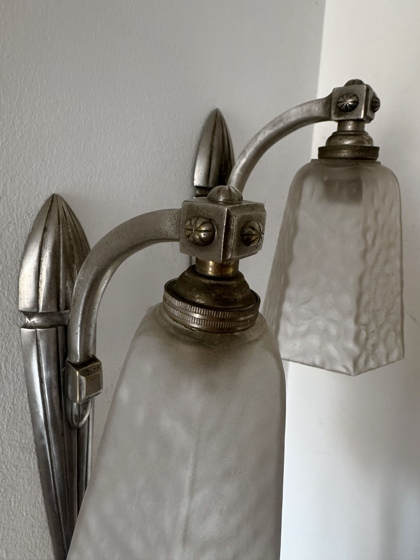Silver Art Deco wall lights with frosted glass.