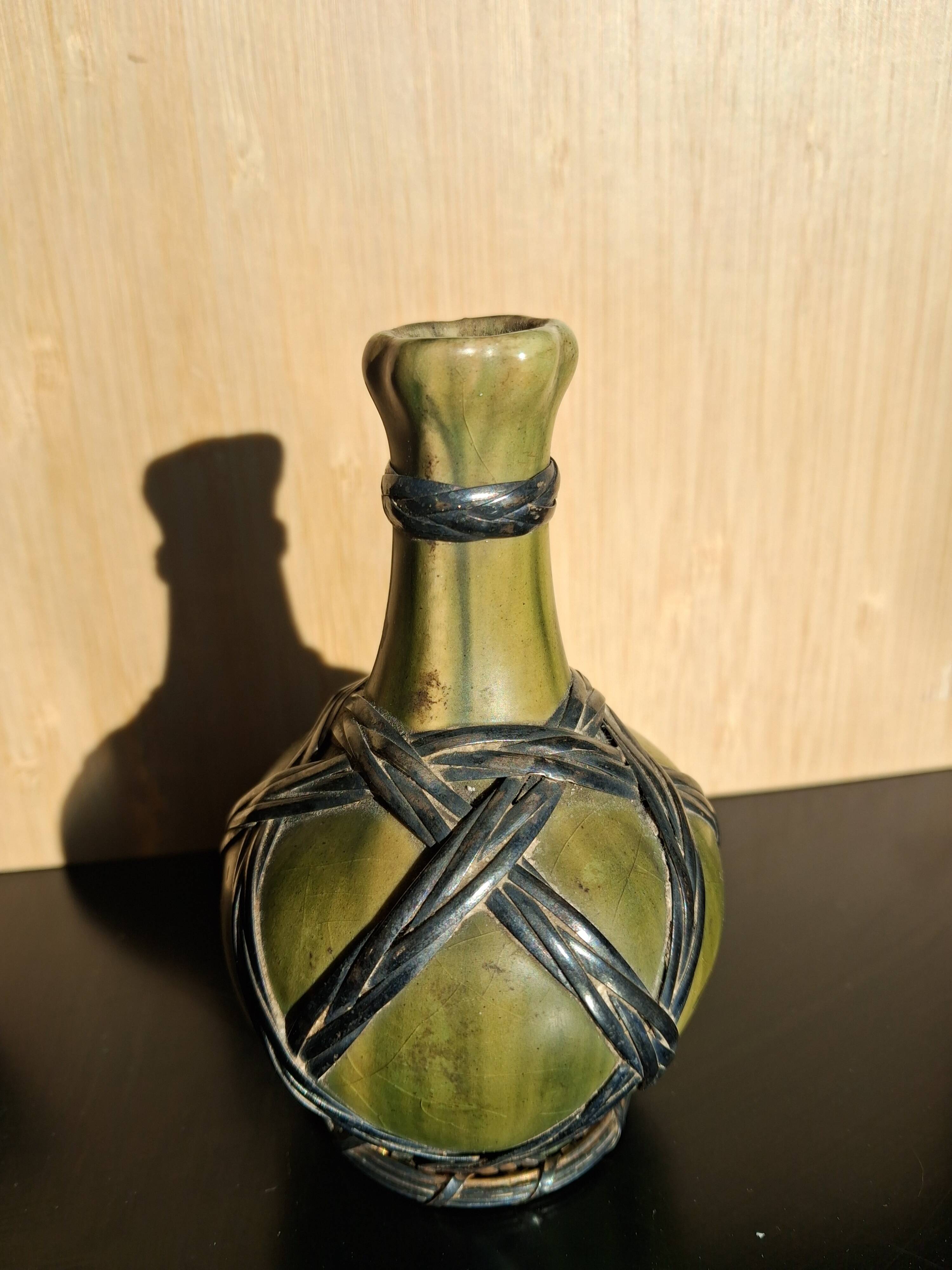 Miniature vase encircled with woven black brass.