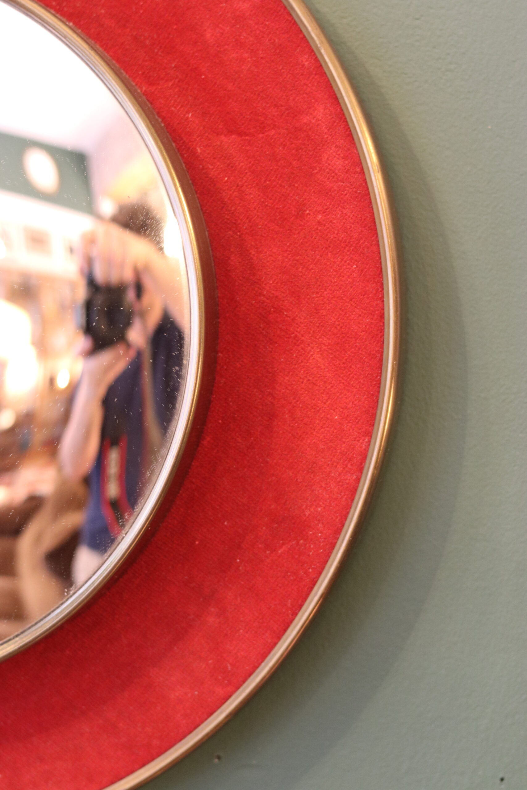 Witch's eye mirror in brass and red velvet
