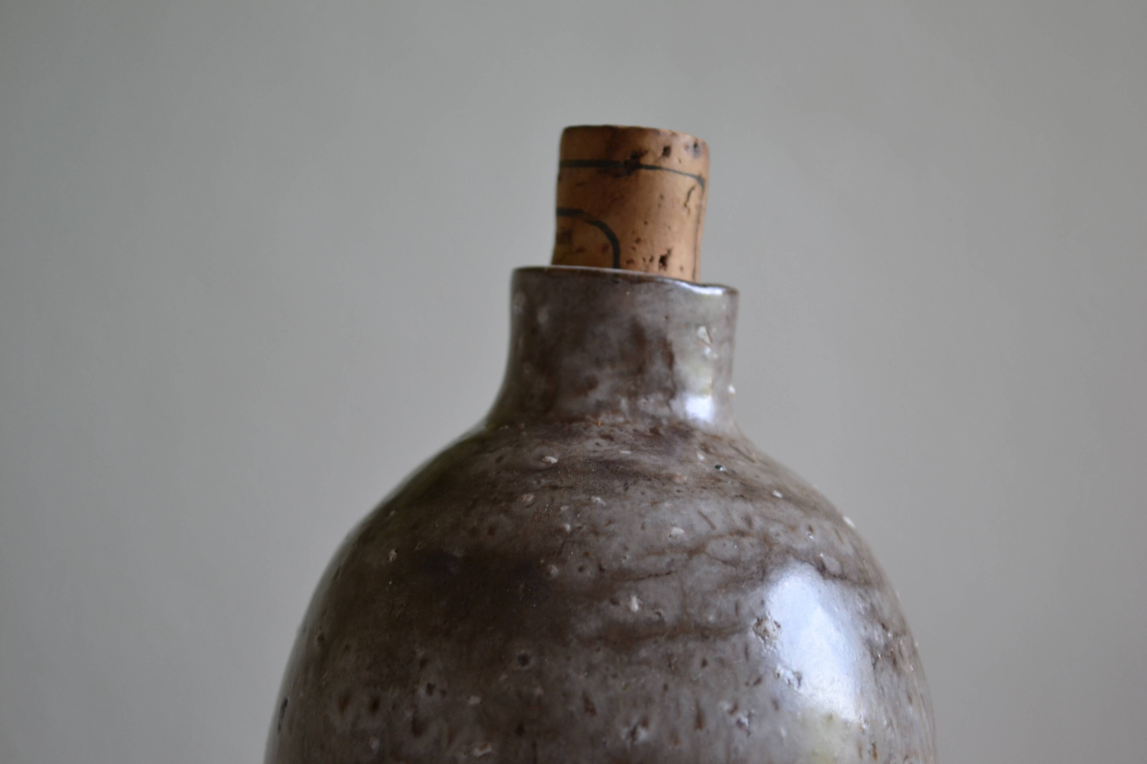Ceramic bottle vase with a fish signature to be identified.