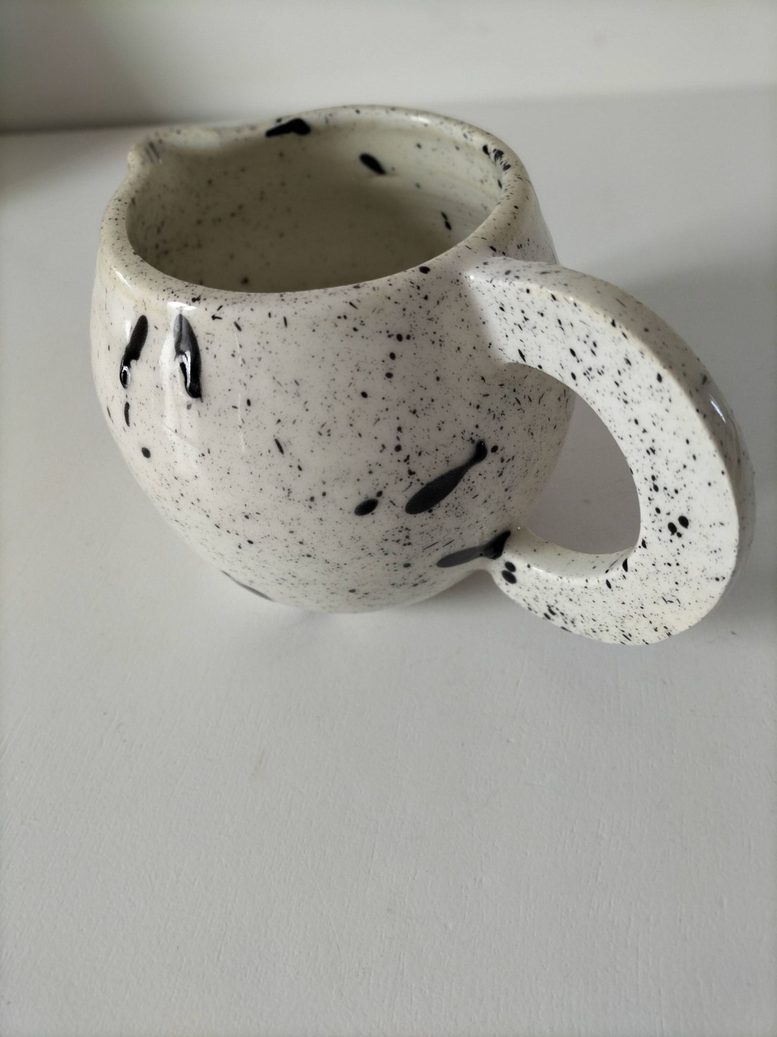 Small speckled ceramic jug in a vintage workshop style.