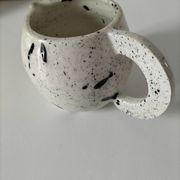 Small speckled ceramic jug in a vintage workshop style.
