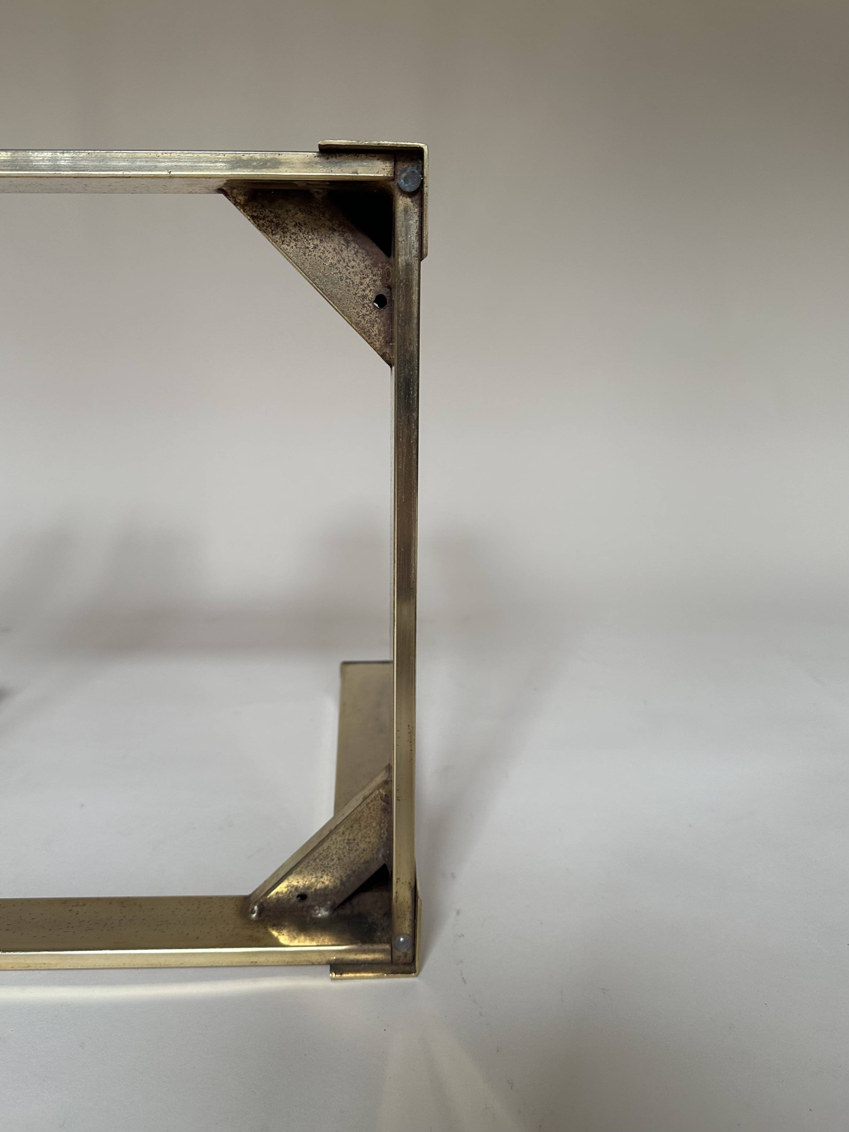 Set of three nesting side tables in brass and smoked mirror.