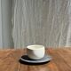 White Indonesian ceramic cup and gray saucer