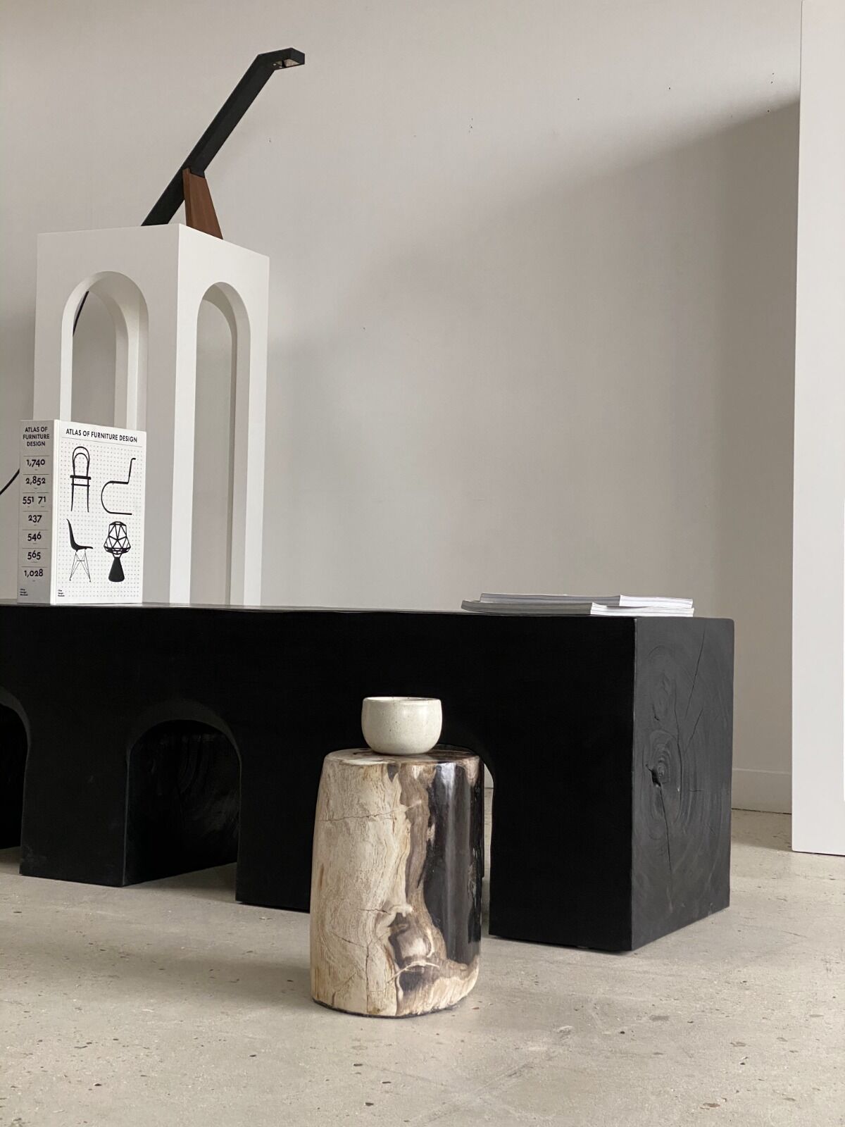 Black solid monoxyl wood bench carved into 3 arches