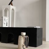 Black solid monoxyl wood bench carved into 3 arches