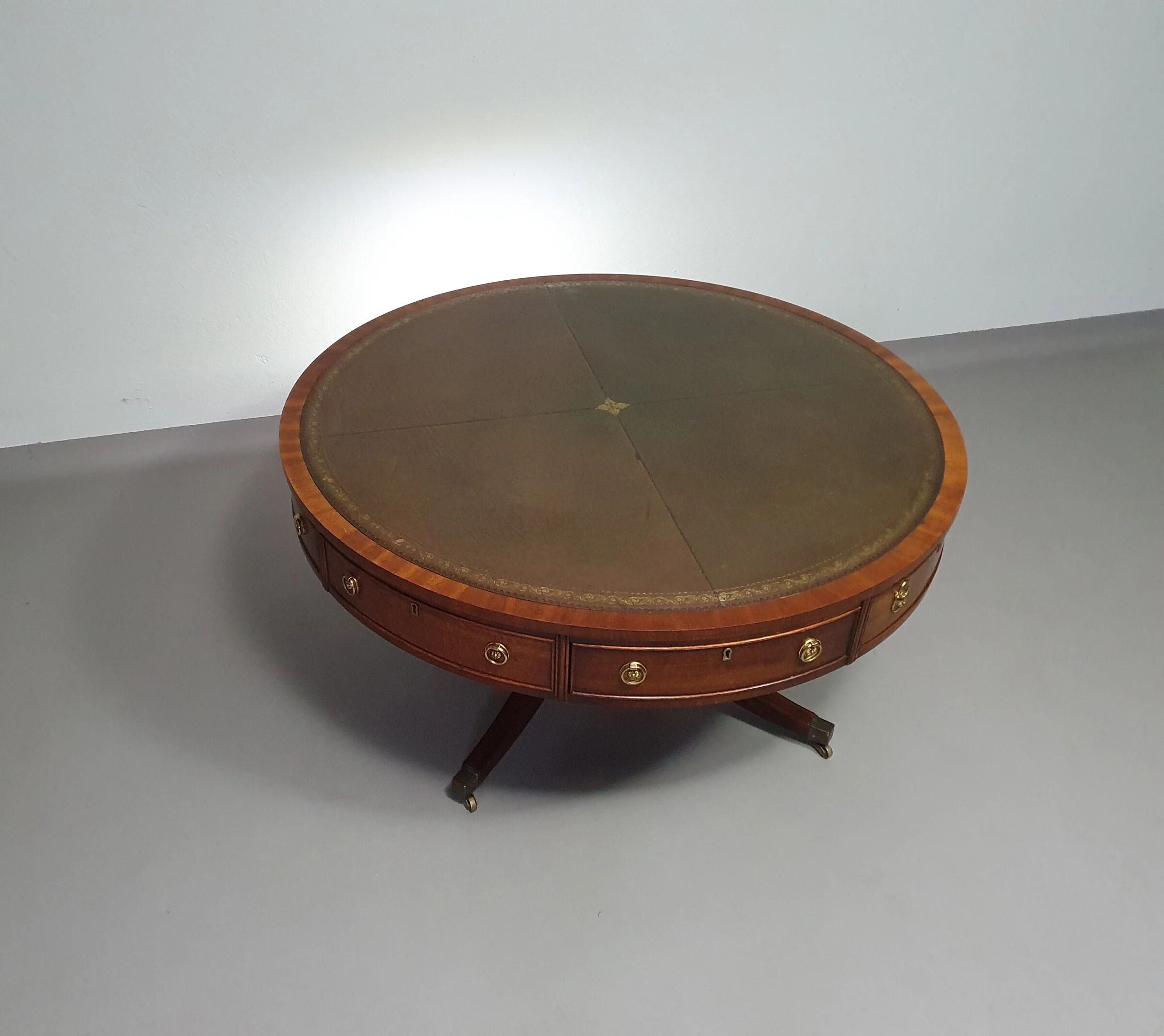 Table basse / table tambour victorienne « Heldense » en acajou avec plateau en cuir sur roulettes en laiton. Années 1980