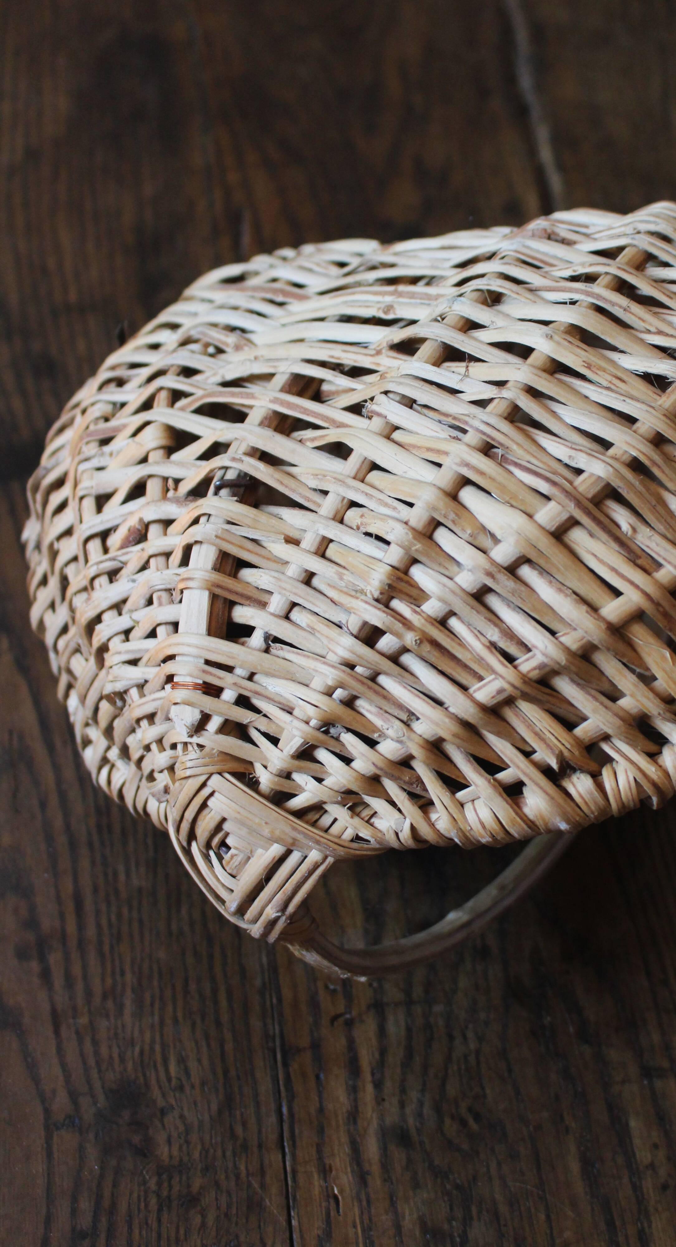 Light wicker oval basket with vintage round handle