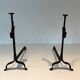 Pair of wrought iron andirons with adjustable supports and tripod feet.