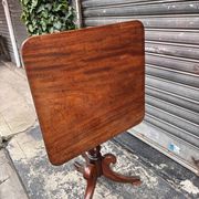 19th-century solid mahogany table with a tilting top and brass mechanism.