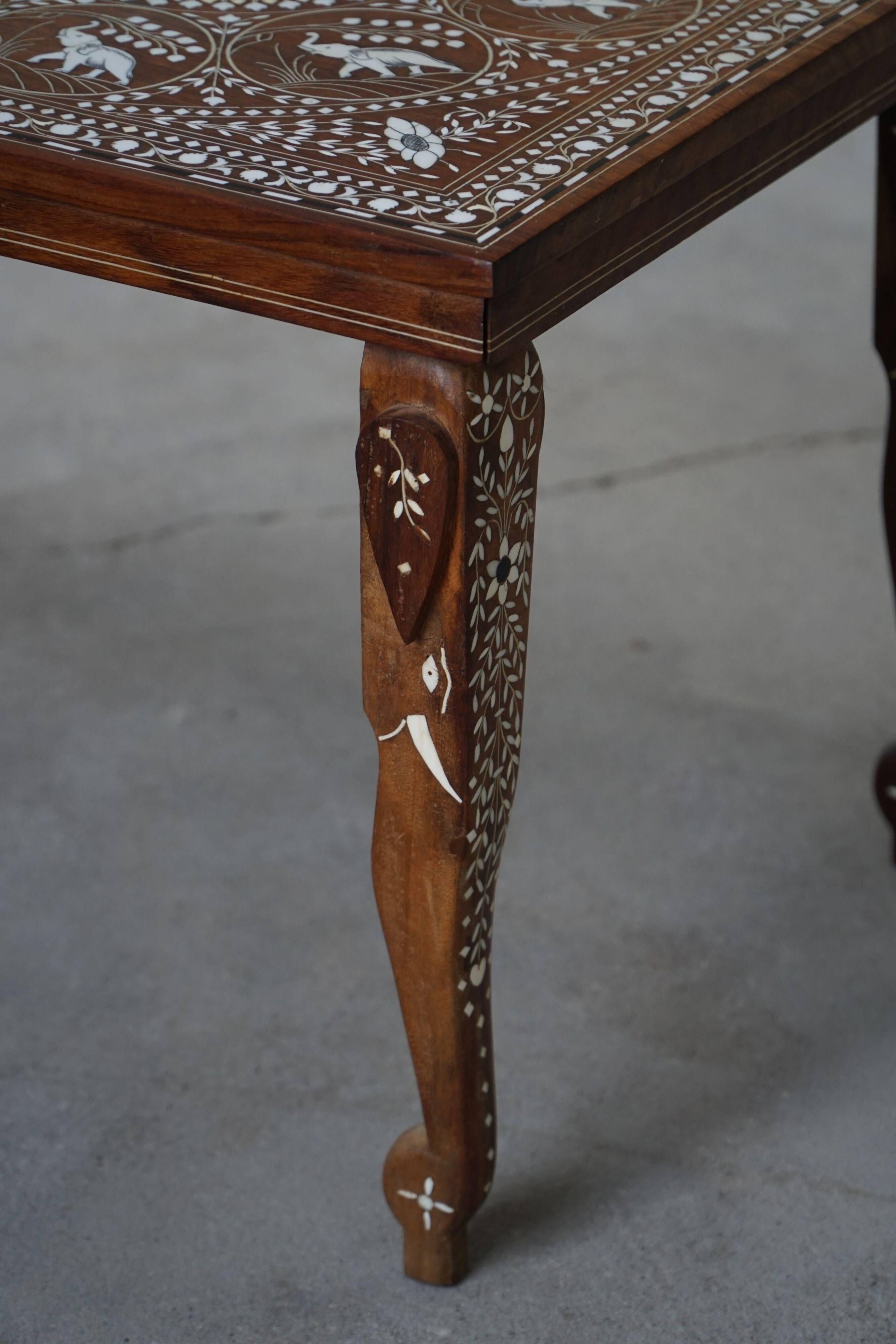 Vintage Indian teak coffee table inlaid with elephant motifs, mid-20th century.