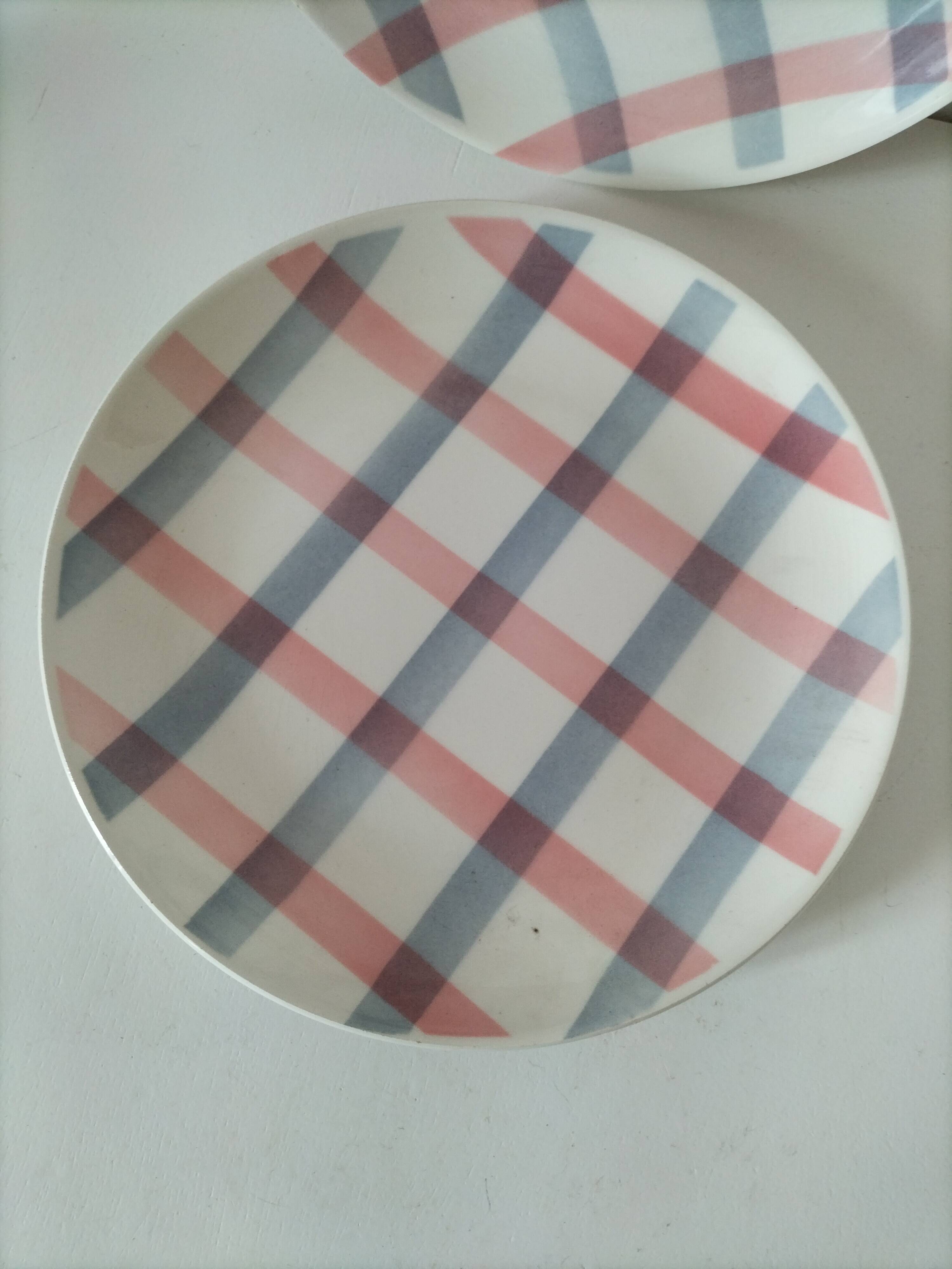 Two dessert plates Moulin des Loups with a pink and grey tablecloth design.