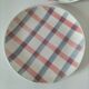 Two dessert plates Moulin des Loups with a pink and grey tablecloth design.