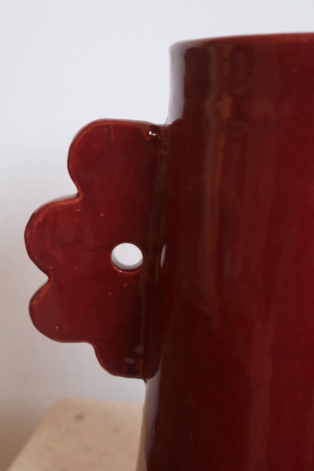 Handmade abstract ceramic vase with asymmetrical handles and burgundy flower